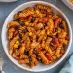 An overhead shot of chicken enchilada pasta in a bowl with another bowl on the side.