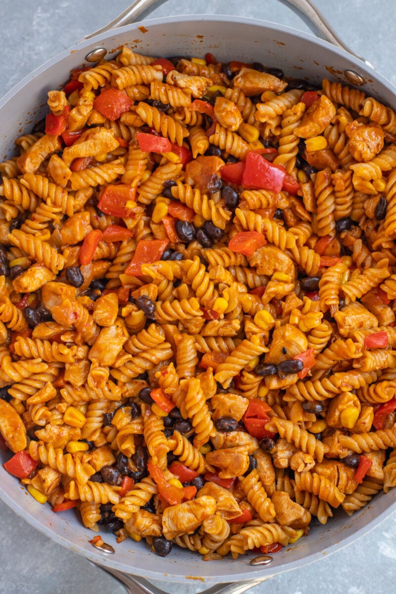 A close up of chicken enchilada pasta in a skillet.