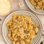 French Onion Orzo on a plate with a fork resting on the plate and another plate on the side.