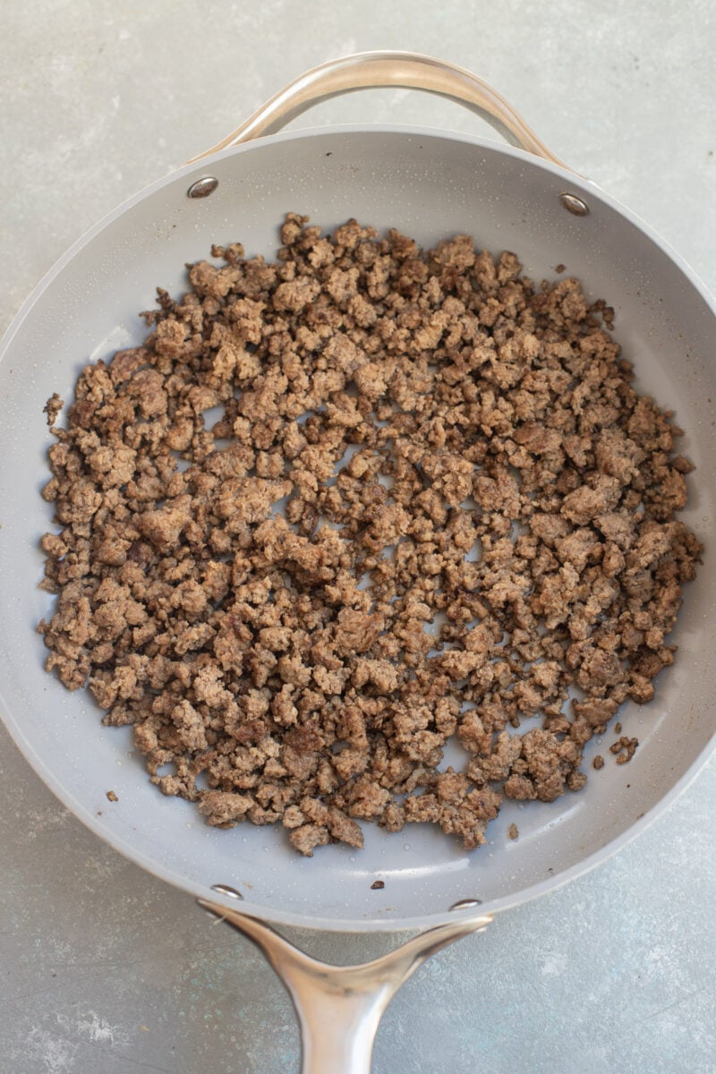 Ground Beef browned in a skillet on a counter. 