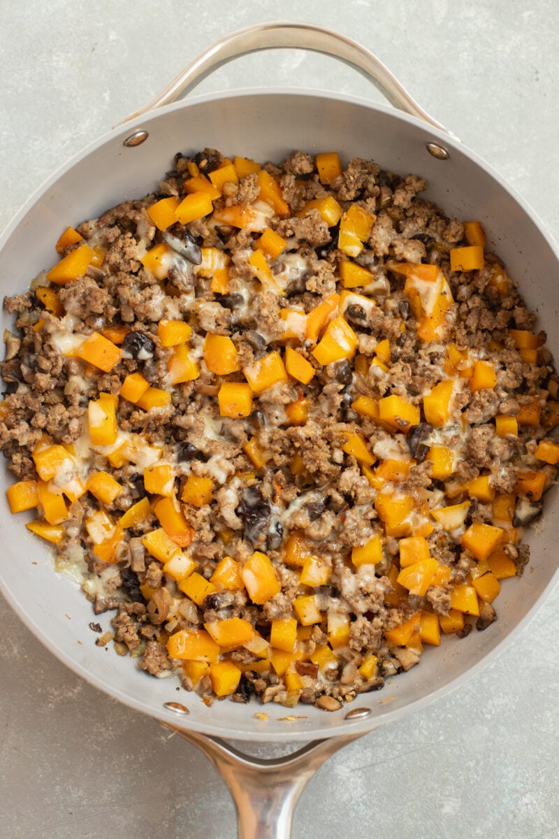 Ground Beef Butternut Squash with Cheddar in a skillet pan on a counter. 