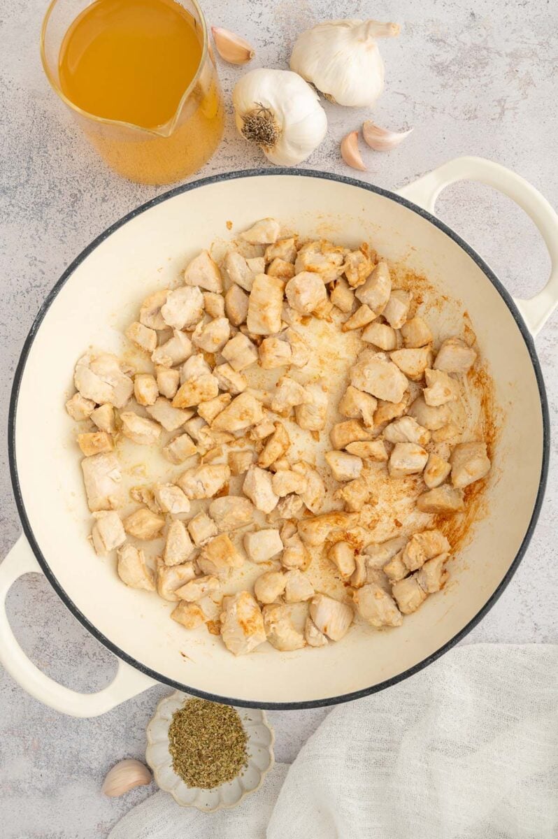 Cubed cooked chicken in a dutch oven.