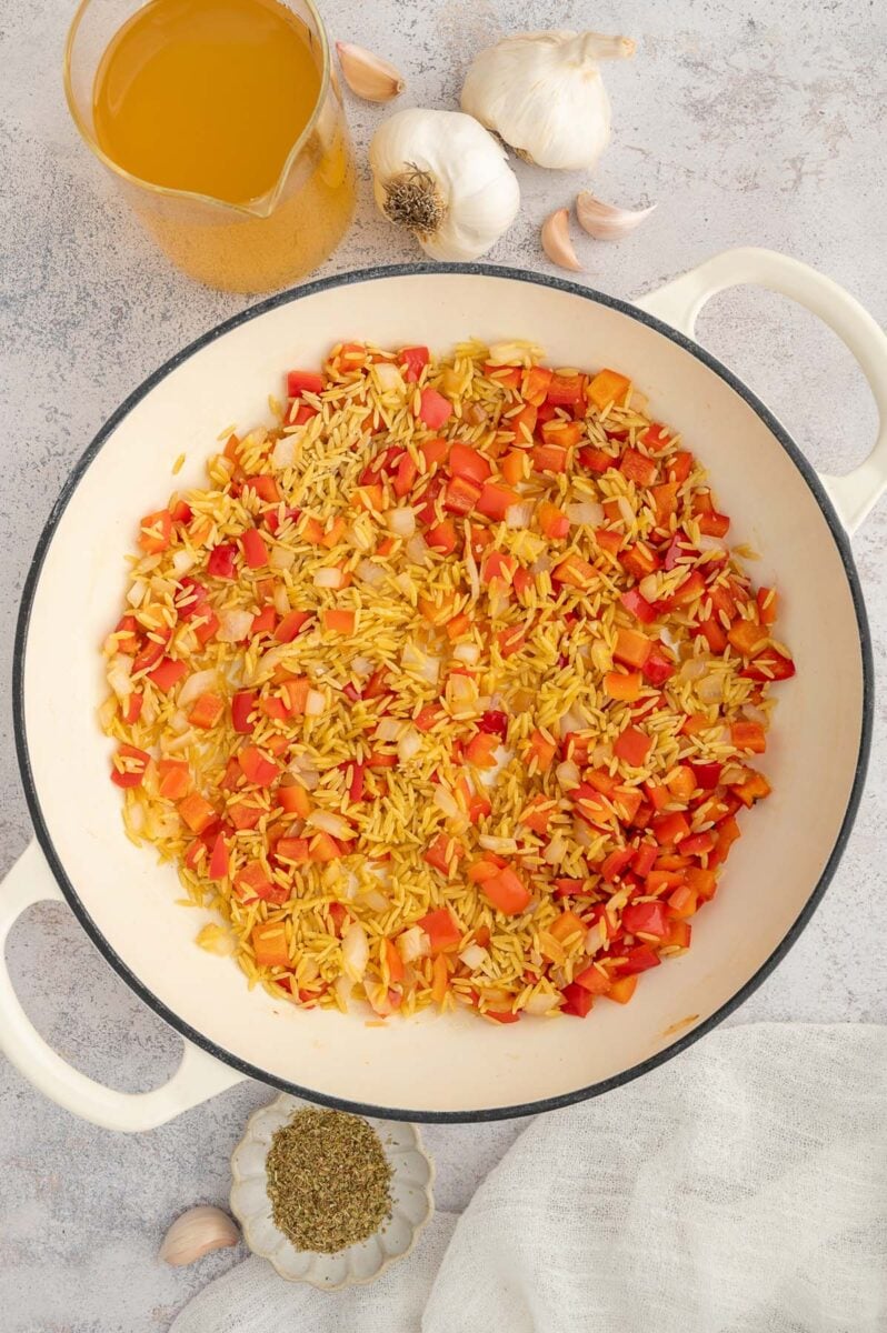 Peppers, onion, and orzo in a dutch oven after sautéing.