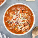 a large bowl of 15 bean soup with spoons and saltines on the side