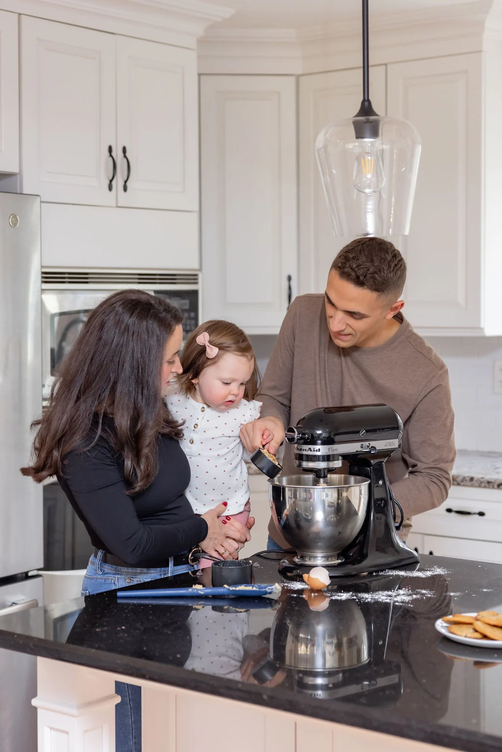 elizabeth and tyler marino in their kitchen making cookies with their daughter