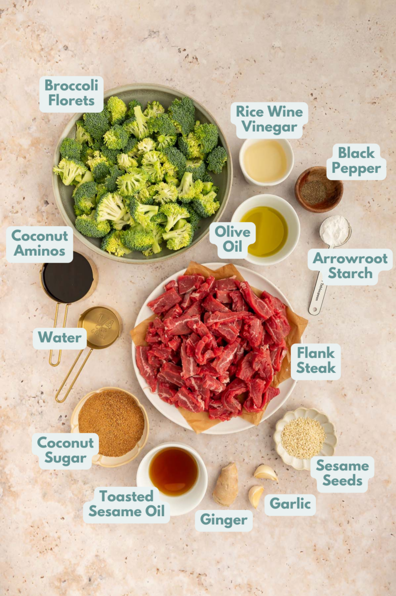 Ingredients to make beef and broccoli in bowls and measuring cups on a counter.