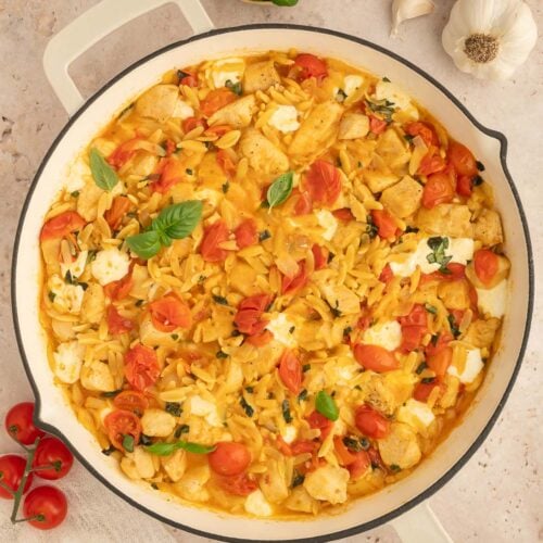 An overhead shot of chicken caprese orzo in a pan.
