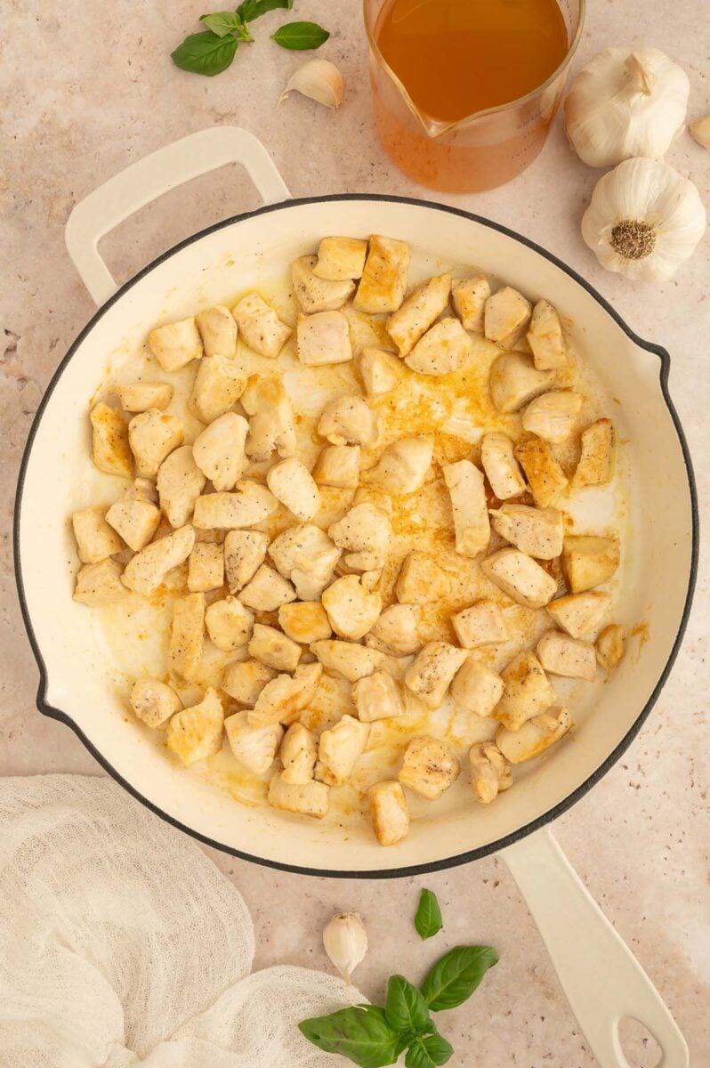 Chicken pieces browning in a skillet. 