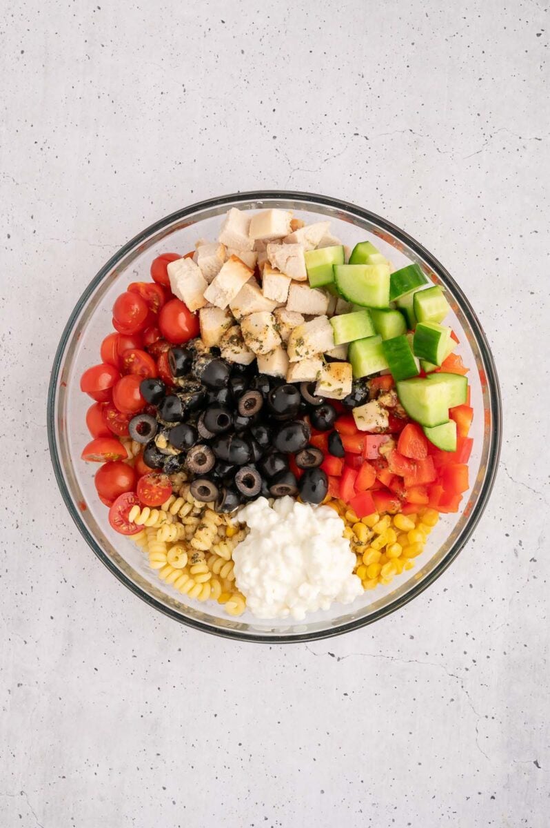 Ingredients for high protein pasta salad in a bowl before mixing together.