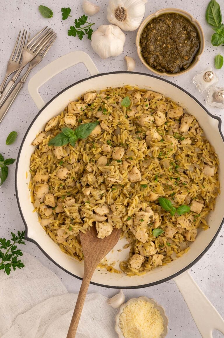 Pesto Chicken Orzo in a skillet with a wooden spoon in it.