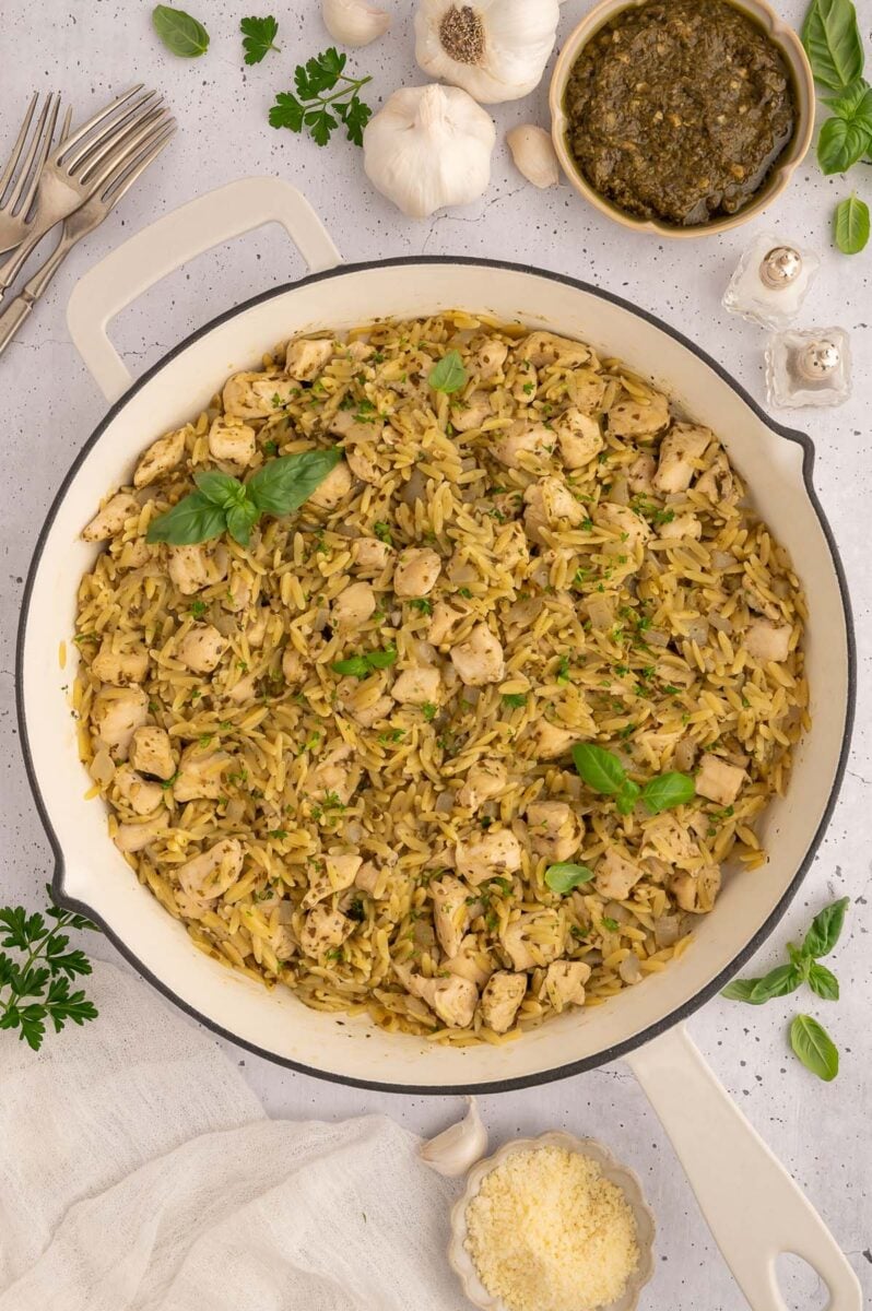 Pesto Chicken Orzo in a skillet with pesto on the side. 
