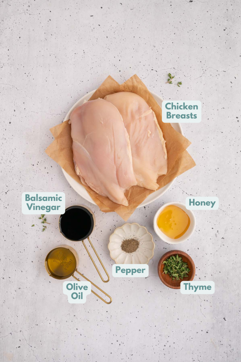 Ingredients to make balsamic chicken in bowls and measuring cups on a counter.