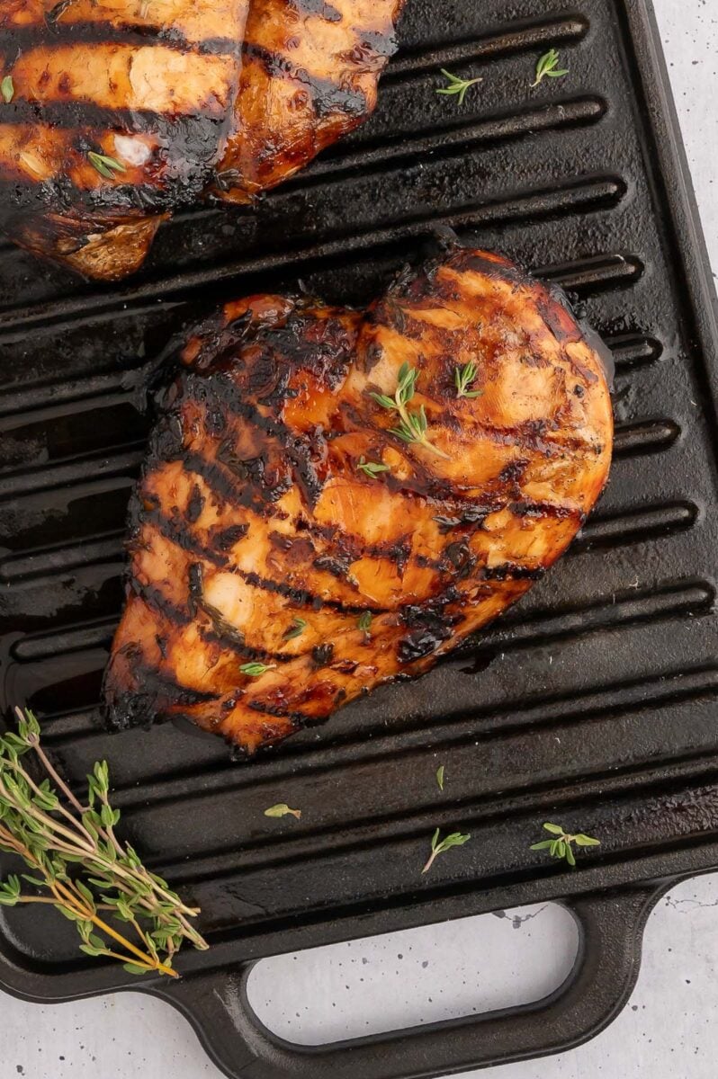 Balsamic grilled chicken with grill marks on a black stovetop grill pan. 