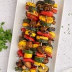 BBQ Grilled Vegetables on kabobs on a white platter.
