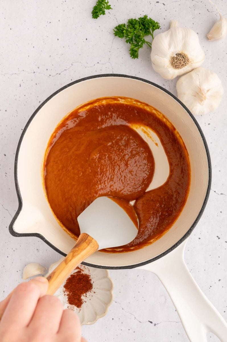 A spatula stirring healthy bbq sauce in a pot.