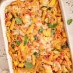 Vegetable Baked Ziti in a white baking dish with a spoon in it.
