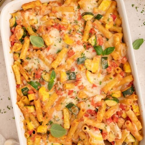 Vegetable Baked Ziti in a white baking dish with a spoon in it.