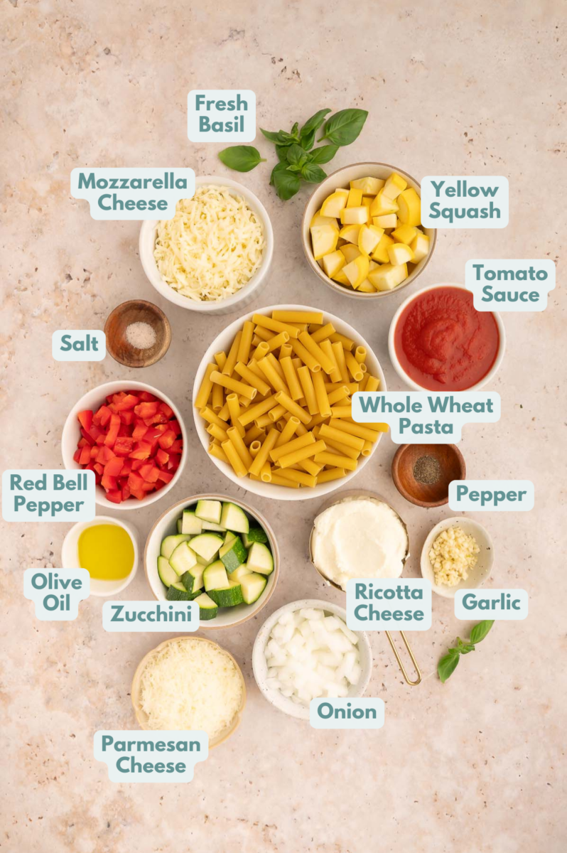 Ingredients to make vegetable baked ziti in bowls and measuring cups on a counter.