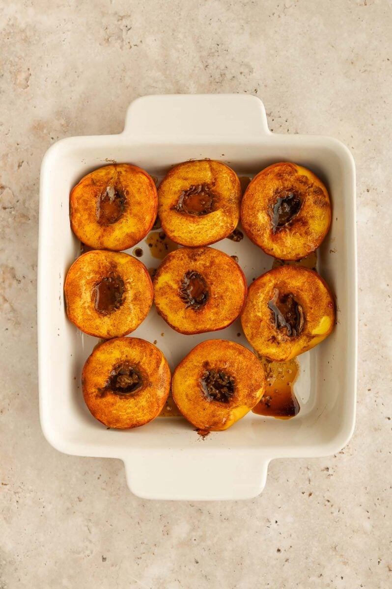 Baked peaches in a baking dish.