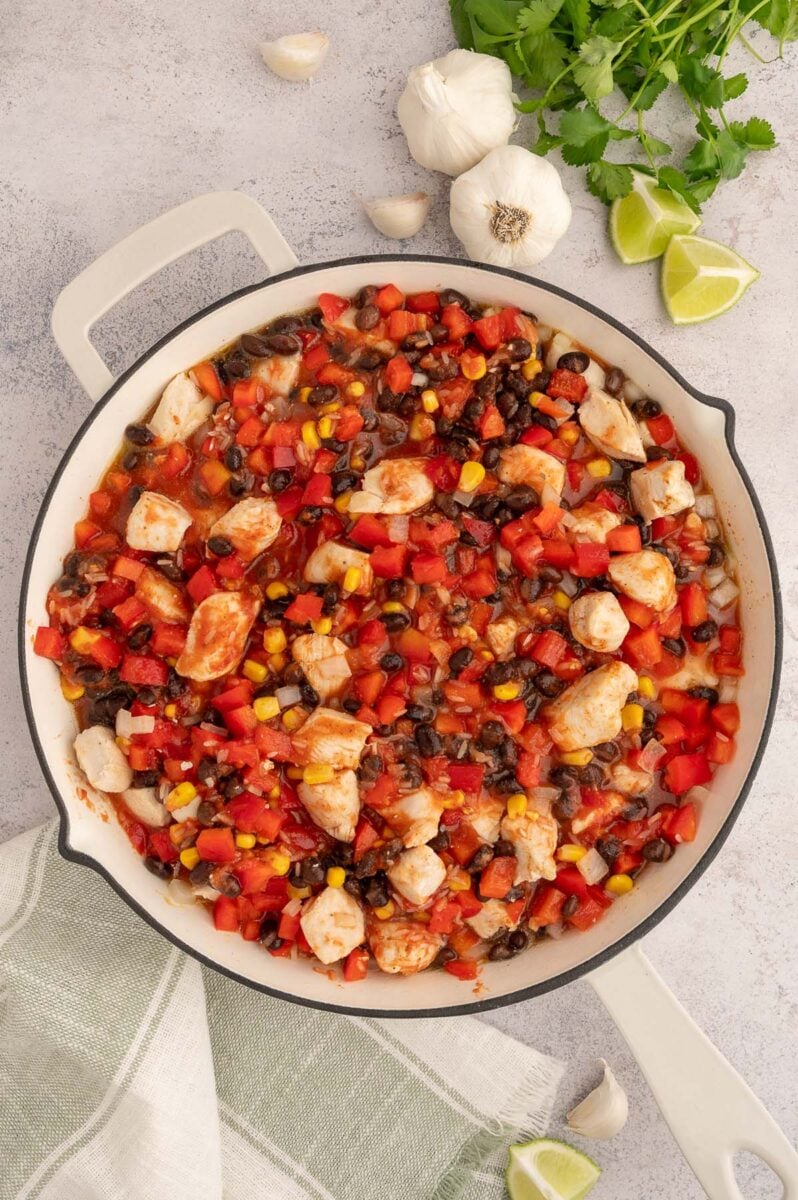 Uncooked chicken taco rice in a skillet.