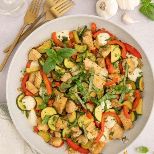 Chicken Vegetable Skillet in a grey pan with ingredients on the side.