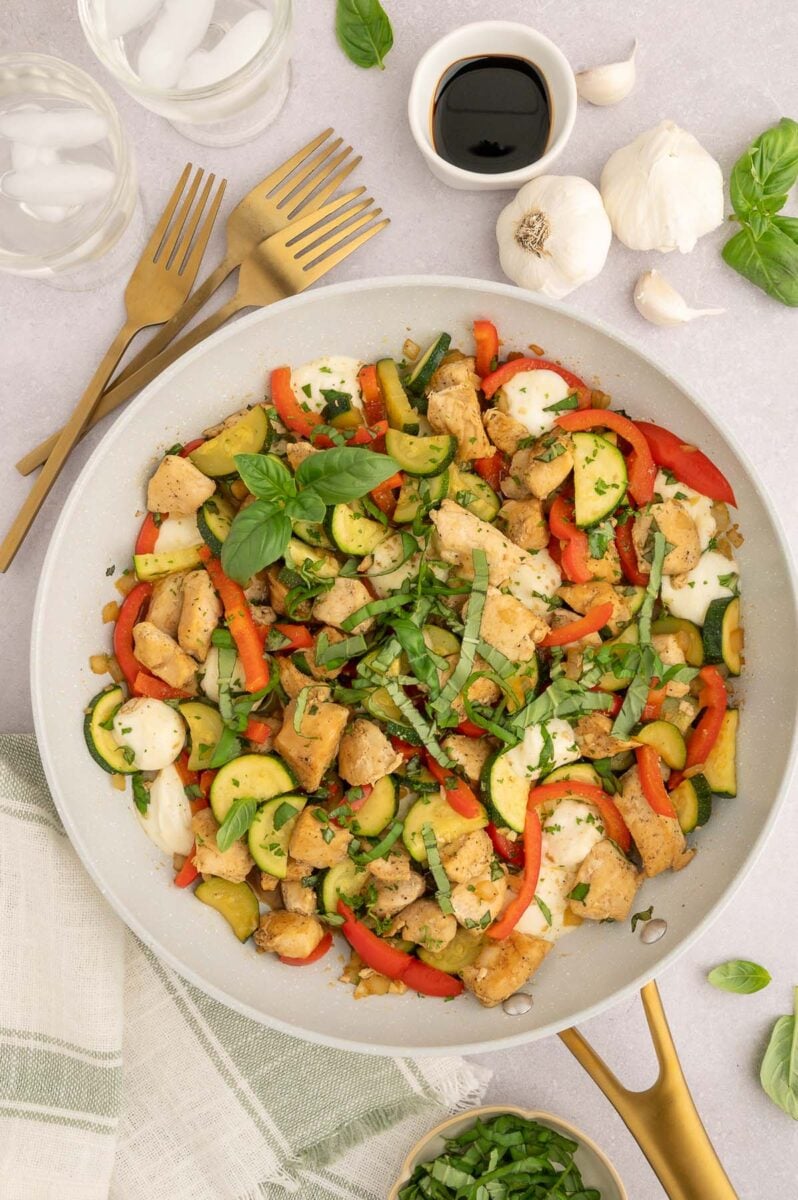 Chicken Vegetable Skillet in a grey pan with ingredients on the side.