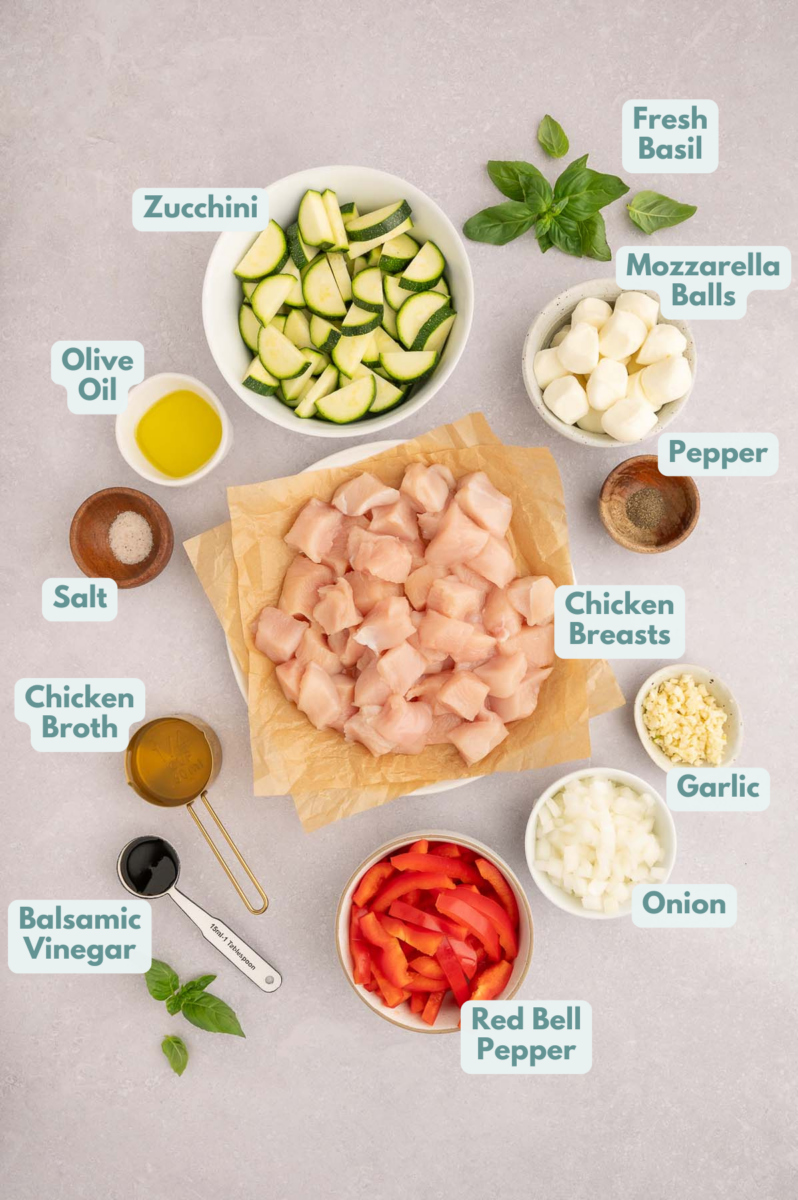 Ingredients to make chicken vegetable skillet in bowls and measuring cups on a counter.