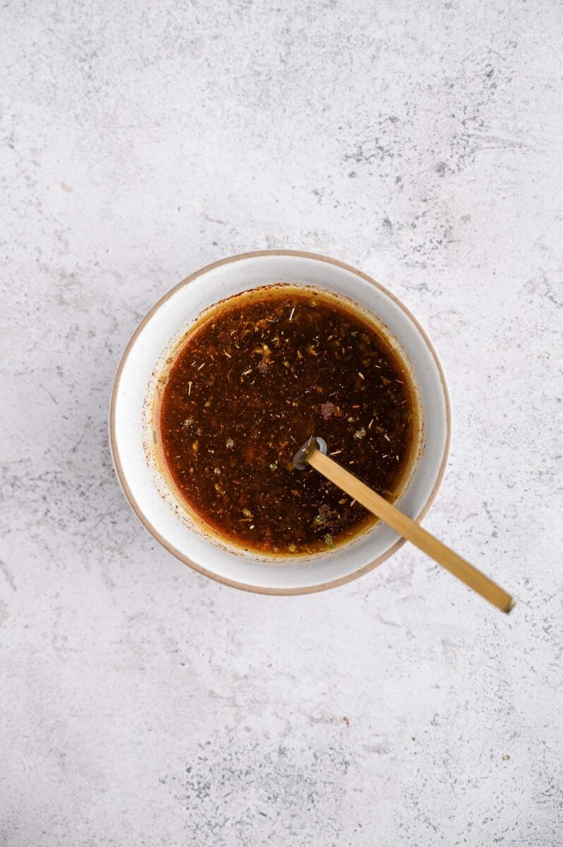 Chili lime steak marinade in a bowl with a spoon in it. 