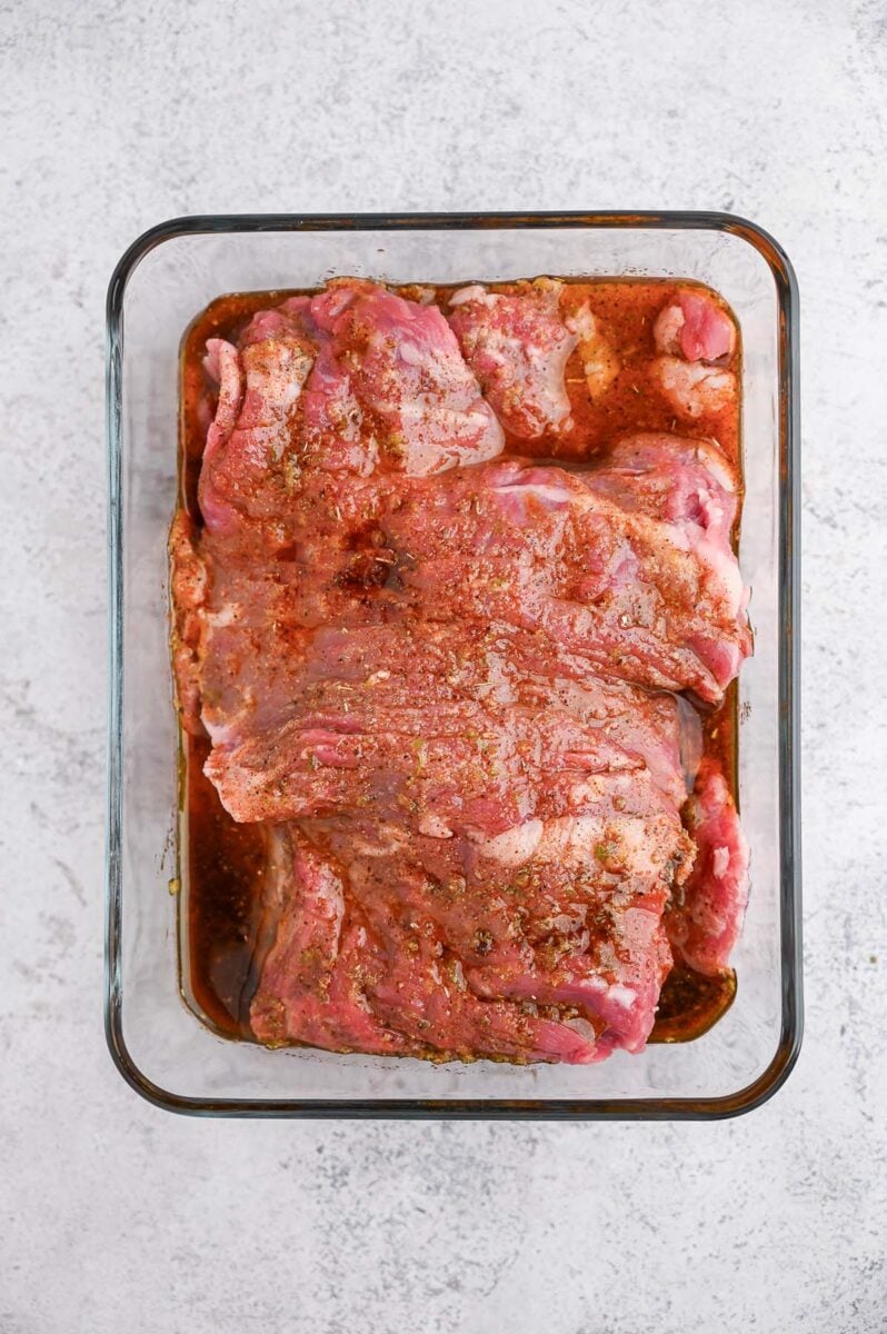 Skirt steak in a glass baking dish in a chili lime marinade. 