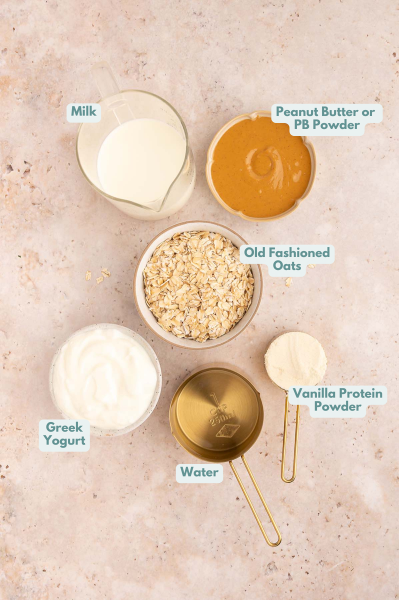 Labeled ingredients to make protein oatmeal in small bowls and measuring cups.