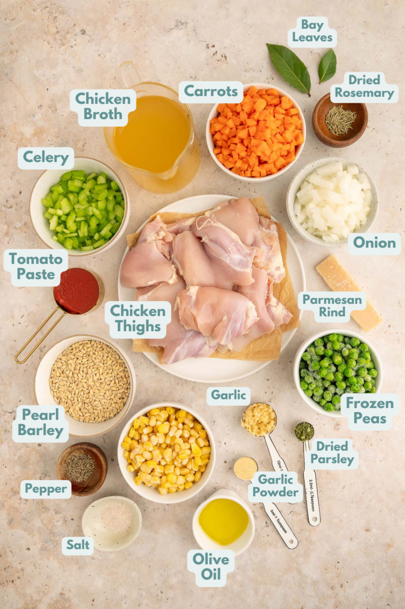 Labeled ingredients to make chicken barley soup in small bowls and measuring cups.