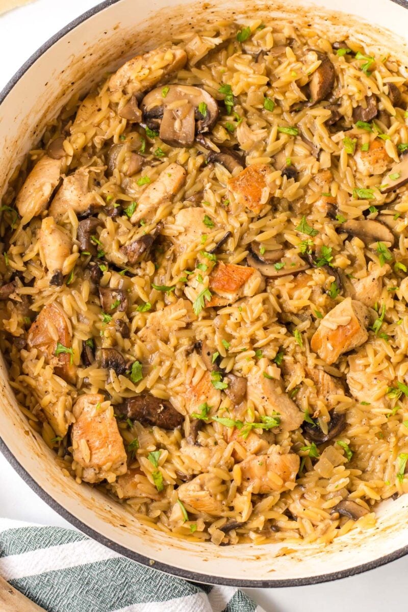 A close up of chicken marsala orzo in a pot.