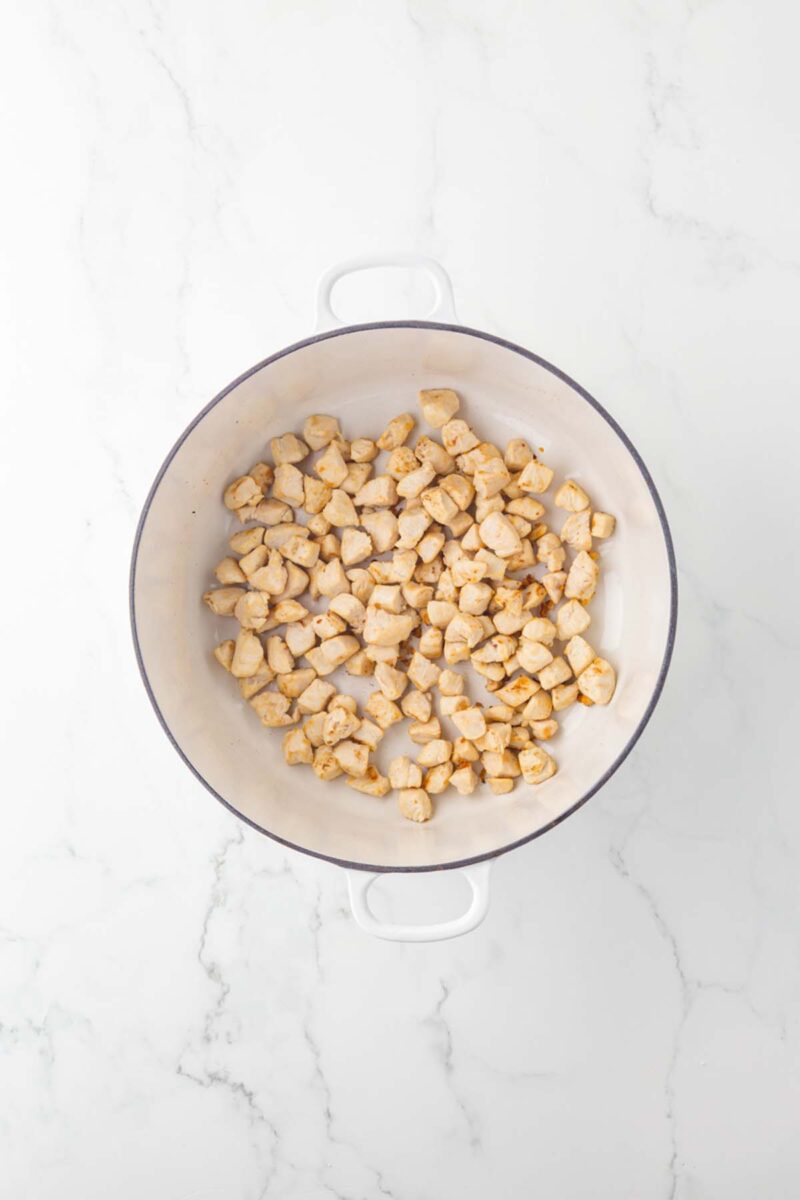 Chicken pieces in a large pot after cooking until golden brown.