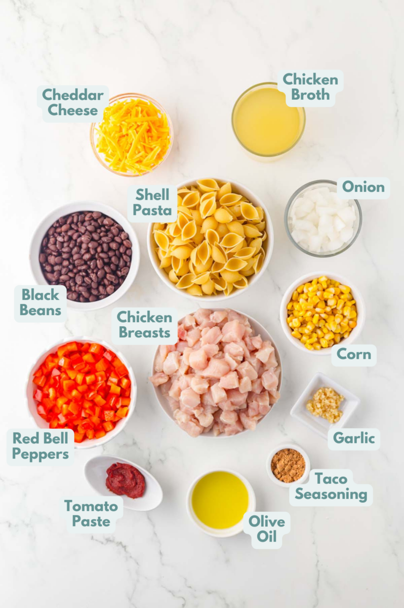Labelled ingredients for chicken taco pasta laid out in separate bowls.