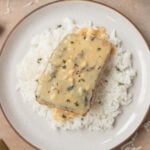 Creamy Garlic Salmon on a bed of white rice on a plate.