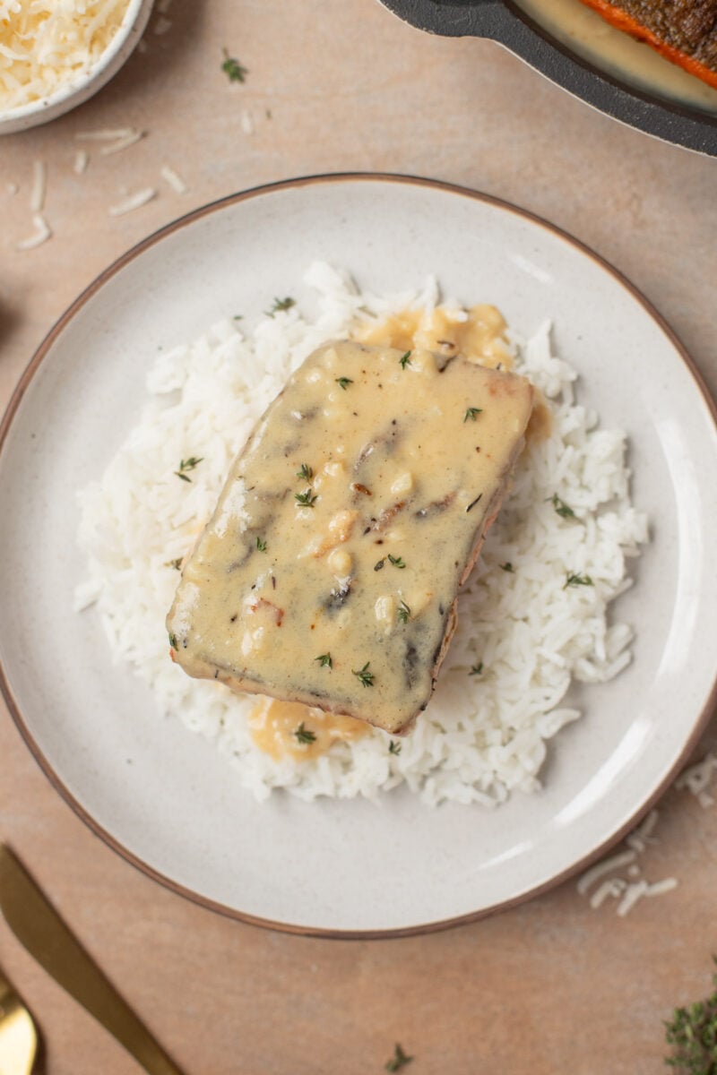 Creamy Garlic Salmon on a bed of white rice on a plate.