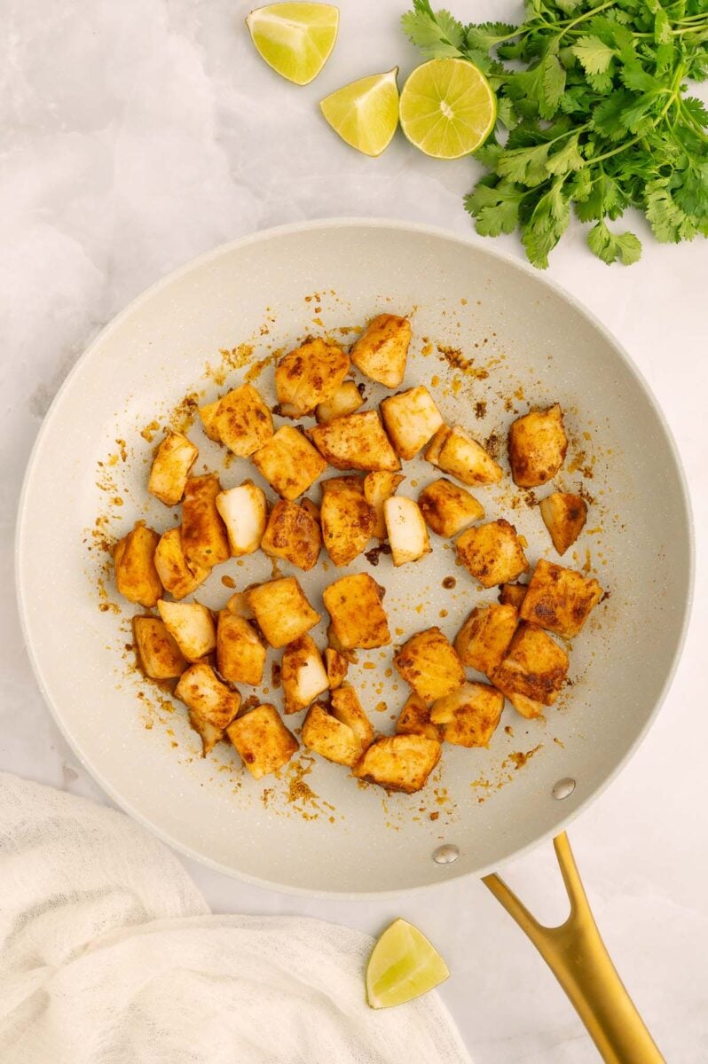 Cooked halibut in a pan for healthy fish tacos.