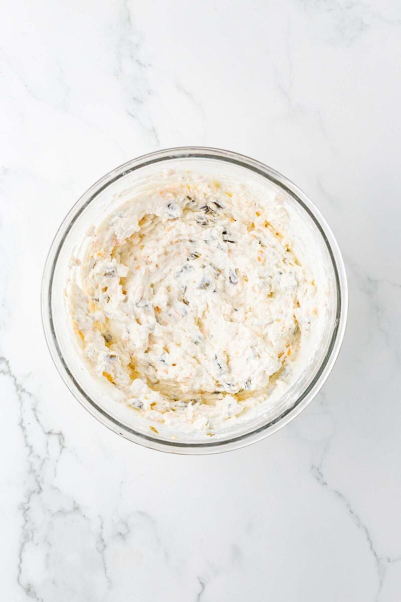 Uncooked healthy jalapeno popper dip in a clear bowl.