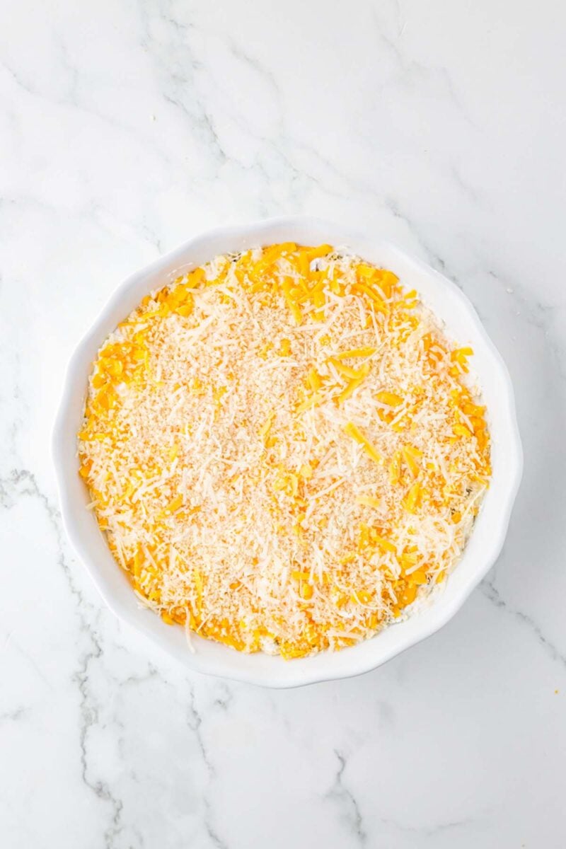 Uncooked jalapeno popper dip in a round white baking dish.