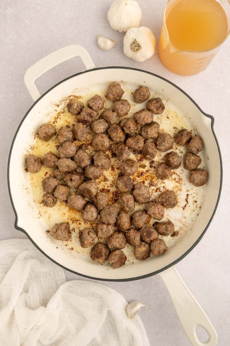 Small meatballs in a skillet after cooking for italian wedding orzo.