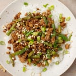 A plate of ground pork stir fry on a bed of white rice.