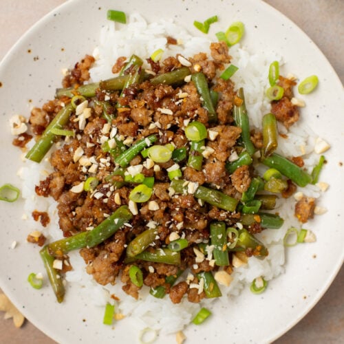 A plate of ground pork stir fry on a bed of white rice.