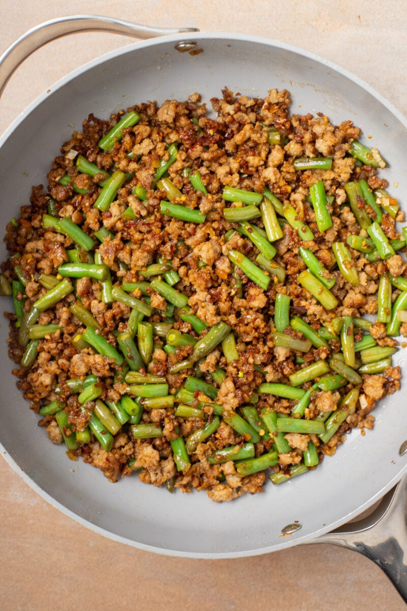 Healthy ground pork stir fry in a saute pan.