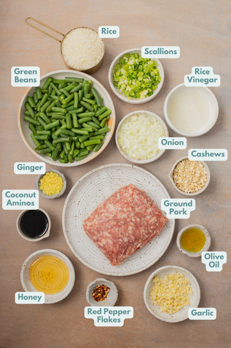 Labeled ingredients to make ground pork stir fry in small bowls and measuring cups.