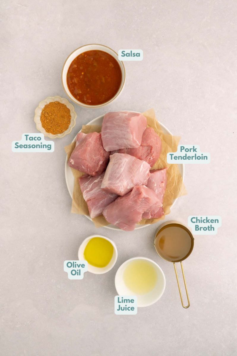 Labeled ingredients to make slow cooker pulled pork tacos in small bowls and measuring cups.