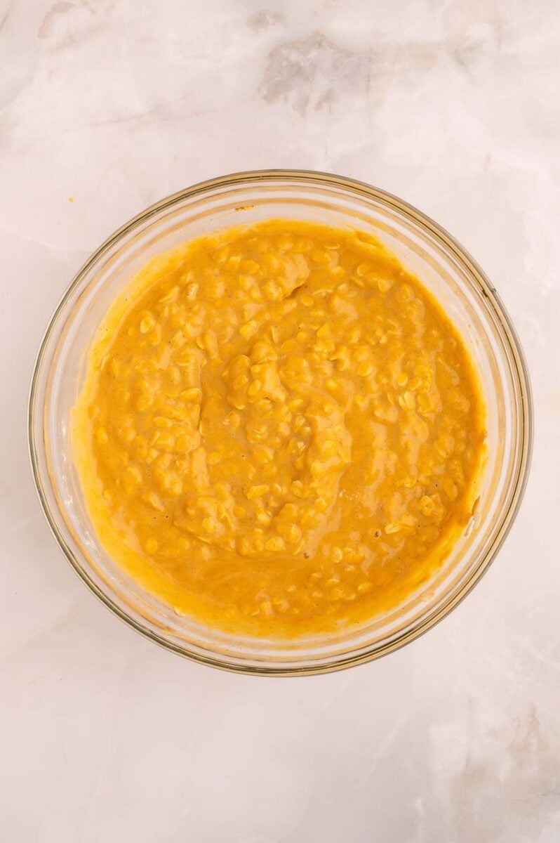 Pumpkin baked oatmeal mixture in a glass bowl.