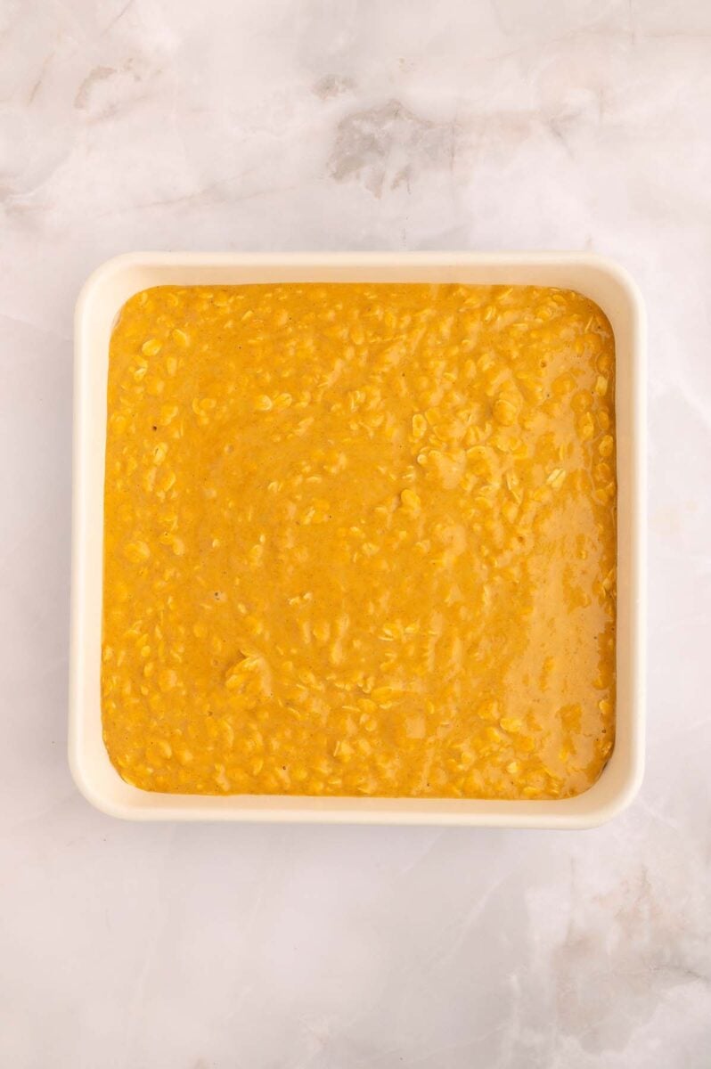Unbaked pumpkin baked oatmeal in a square baking dish.