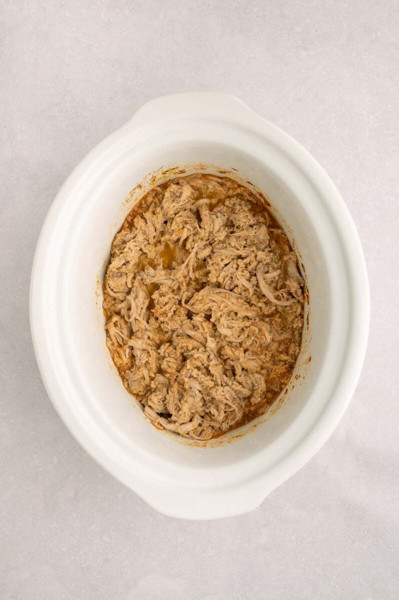 Pulled pork for tacos in a white crockpot base.
