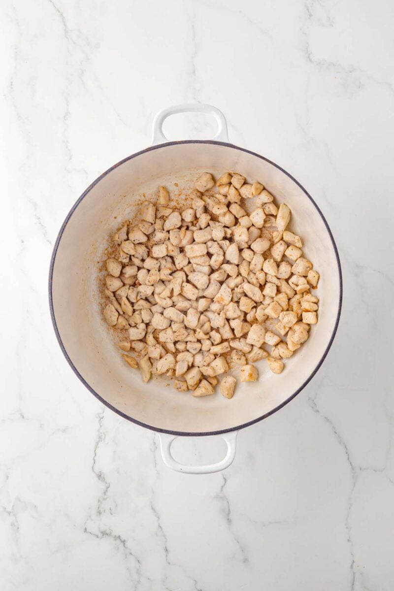 Golden brown chicken pieces in a dutch oven.