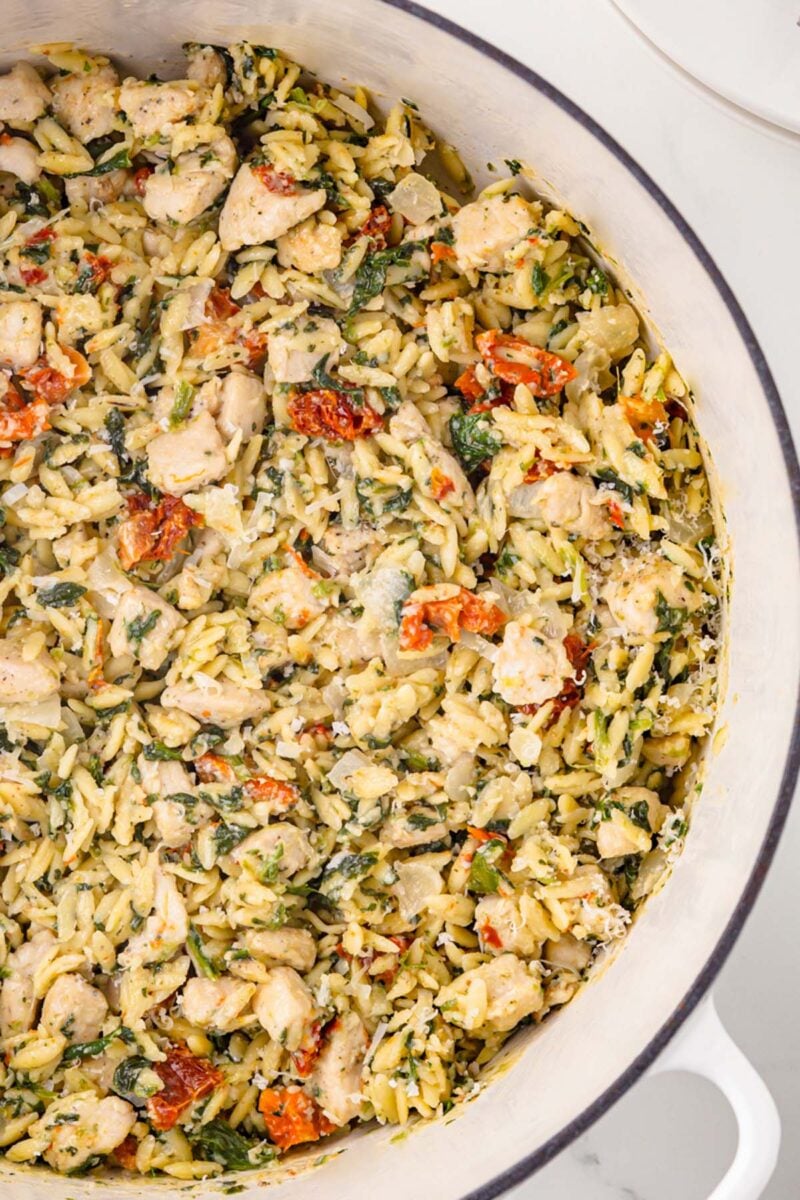 A close up of Tuscan Chicken Orzo in a dutch oven.